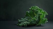  A Close Up Of A Leafy Green Vegetable On A Black Surface With A Dark Background In The Middle Of The Image Is A Single Leafy Green Leafy Vegetable.