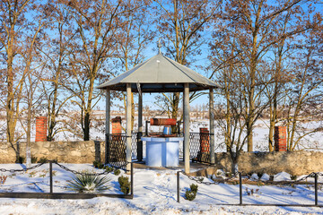 Wall Mural - Well in a winter village. Background with selective focus and copy space