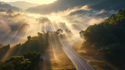 Canvas Print -  the sun shines through the clouds over a road in the middle of a forested area with trees on both sides of the road and a mountain range in the distance.