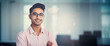 Bellissimo uomo di 30 anni di origini indiane sorride in ufficio con camicia elegante e grafici sullo sfondo