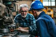 Metal worker teaching trainee on machine use