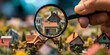© ParinApril - Hand holding a magnifying glass over miniature houses