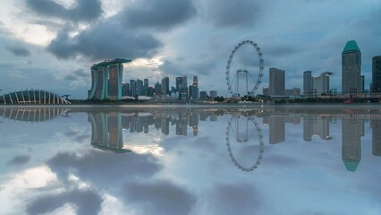 Wall Mural - 4k time lapse of sunset day to night scene at Marina Bay Singapore city skyline with reflection effect. Tilt up