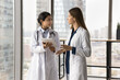 © fizkes - Two diverse doctor women using tablet, discussing medical case, electronic records, online healthcare service, holding digital gadget, talking, consulting each other
