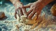  a close up of a person kneading dough on top of a table with other kneads and doughnuts on the table next to the person is kneading the dough.