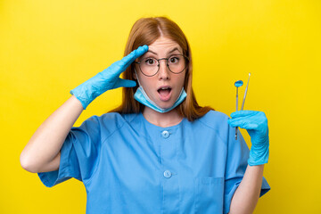 Wall Mural - Young redhead Dentist woman isolated on yellow background with surprise expression