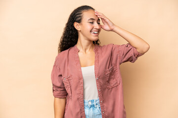 Wall Mural - Young woman isolated on beige background smiling a lot