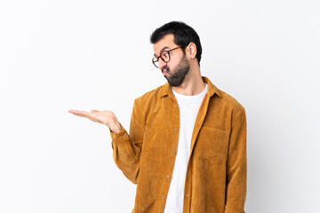 Wall Mural - Caucasian handsome man with beard wearing a corduroy jacket over isolated white background holding copyspace with doubts