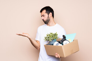 Wall Mural - Man holding a box and moving in new home over isolated background holding copyspace with doubts