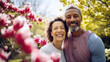 Joyful middle age couple surrounded by pink spring blossoms sharing a moment