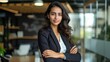 © Hope - Amazing successful positive indian or arabian business woman, secretary, ceo manager dressed in a stylish suit standing in a modern creative office, looking and smiling at camera