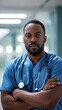 © Hope - Successful black male practitioner posing over white background, panorama hospital with copy space