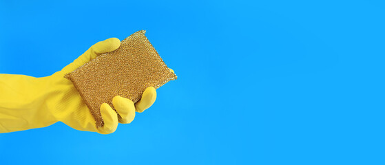 Female hands in latex gloves hold a sponge-scraper for washing Teflon surfaces. Professional cleaning. Household gloves, yellow. Cleaning woman