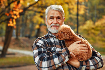 Wall Mural - Senior couple walking in the park in autumn