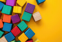 Top View On Multicolor Toy Wooden Bricks On Yellow Background With Copy Space For Text. Children Toys On The Table.