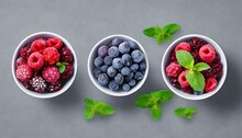 Top View Three Bowls Of Frozen Berries And Mint Leaves Arrangement On A Grey Background  Healthy Vitamin Food Visualisation Illustration