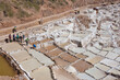 Maras, Peru – May 27 2018: Located in the Sacred Valley, Peru, the Maras Salt Mines or Salineras de Maras are ancient salt pans that have been in operation for more than 500 years. They are mined by l