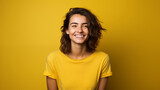 Fototapeta  - Portret studyjny młodej kobiety uśmiechniętej na żółtym tle z dużą ilością wolnego tła