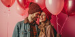 Valentine's Day. Happy couple with red balloons on a pink background. Love and happiness