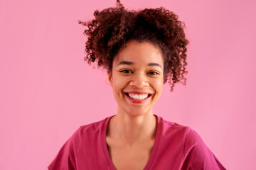 Wall Mural - Attractive smiling female african american with sincere beautiful smile on pink background.