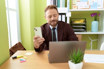 Canvas Print - Middle age man business worker using laptop and smartphone at office