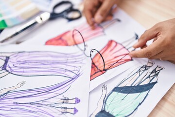 Poster - Young latin man tailor putting glasses on clothing design paper at park