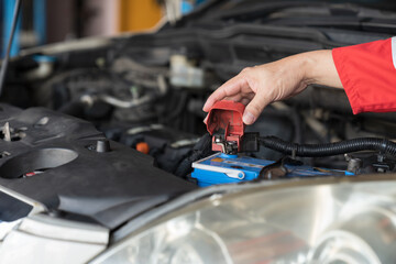 Car mechanic maintenance and auto service shop concept. Hands of mechanic repair, fix car engine in auto repair shop. Technician inspecting quality parts of battery, electronic in garage workshop