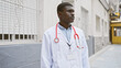 African american male doctor standing thoughtfully in an urban street setting, portraying professionalism and healthcare.