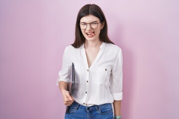 Wall Mural - Young caucasian woman holding laptop sticking tongue out happy with funny expression. emotion concept.