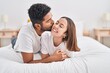 © Krakenimages.com - Man and woman couple lying on bed kissing at bedroom