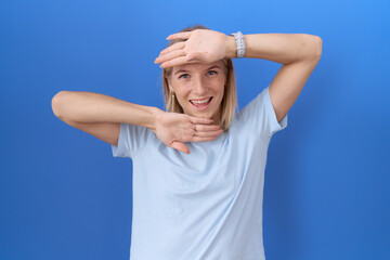 Sticker - Young caucasian woman wearing casual blue t shirt smiling cheerful playing peek a boo with hands showing face. surprised and exited