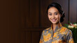 Malay woman in batik dress smiling isolated on pastel background