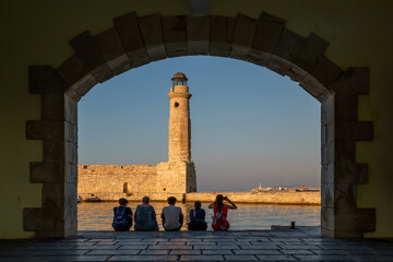 Wall Mural - The Egyptian lighthouse at the old harbor of Rethimno through a frame of an arched door, Crete, Greece.