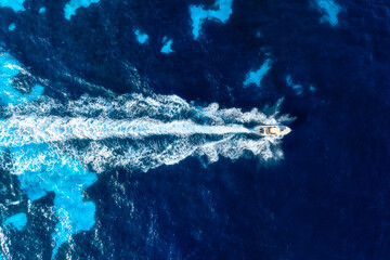 Wall Mural - Vacation and leisure. Aerial view on fast boat on blue Mediterranean sea at sunny day. Fast ship on the sea surface. Seascape from the drone. Seascape from air. Seascape with motorboat.
