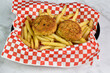 two crab cakes served with french fries