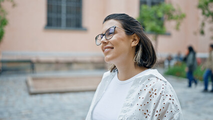 Canvas Print - Beautiful young hispanic woman smiling confident looking to the side in the streets of Stockholm