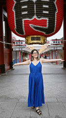 Poster - Joyful hispanic woman in glasses, with arms open, looking around senso-ji temple, tokyo with a beautiful smile embracing the carefree lifestyle.