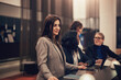 © Flamingo Images - Smiling businesswoman working with colleagues in the lobby of a hotel