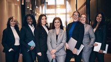 Diverse group of diverse businesswomen laughing in an office lobby