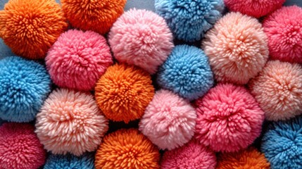 Poster -  a pile of colorful pom poms sitting on top of a blue and pink tablecloth covered in lots of different colors of pom pom pom pom poms.