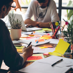 A creative workspace with a group of designers brainstorming, surrounded by colourful sticky notes and design sketches