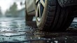 A close up view of a car tire on a wet road. This image can be used to depict rainy weather conditions or to illustrate the concept of driving on wet surfaces