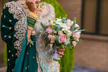 Poster - Indian bride's holding beautiful wedding flowers bouquet close up