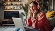Cheerful young woman in headphones having web conference while working from home