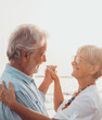 © Daniel - Couple of old mature people dancing together and having fun on the sand at the beach enjoying and living the moment. Portrait of seniors in love looking each others having fun.