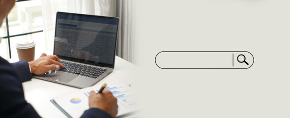 Fototapete - man searching information is typing a keyboard technology search engine optimization on desk in offi