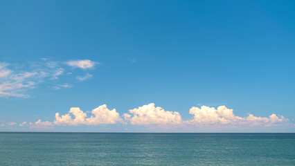 Poster - Blue sky with white clouds over the horizon of the blue sea