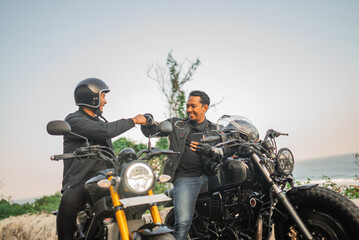 Canvas Print - asian riders sitting on motorcycle with fist bump gesture