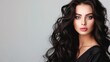 © buraratn - Portrait of elegant stylish young woman with long dark curly healthy shiny hair and makeup on grey banner background