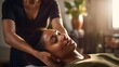 A black african american woman enjoys a massage at a spa salon